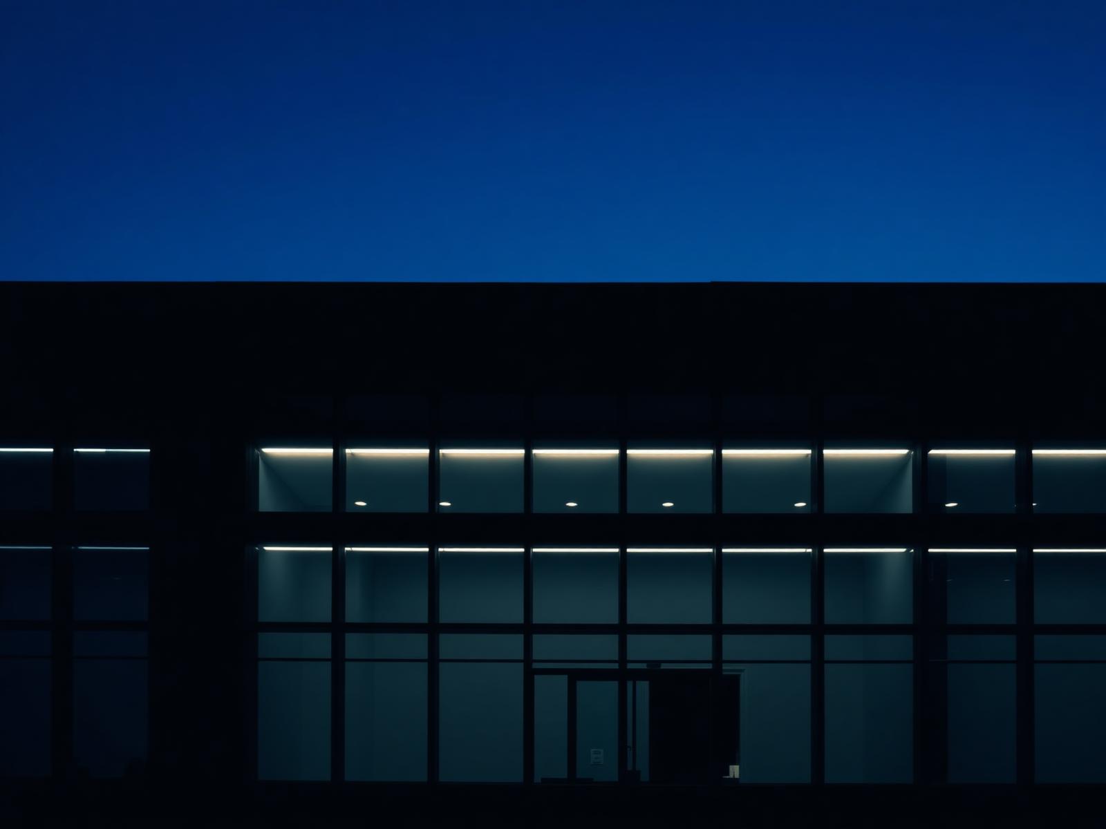 Modern glass office facade lit at dusk